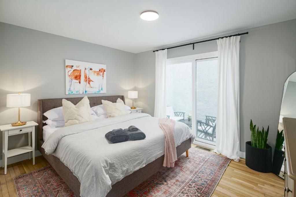 um quarto com uma cama e uma grande janela em 2BR in Heart of Queen Village - walk to everything! em Filadélfia