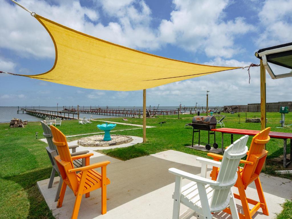 un groupe de chaises et une table avec un parasol jaune dans l'établissement Little Cove Resort, à Taft