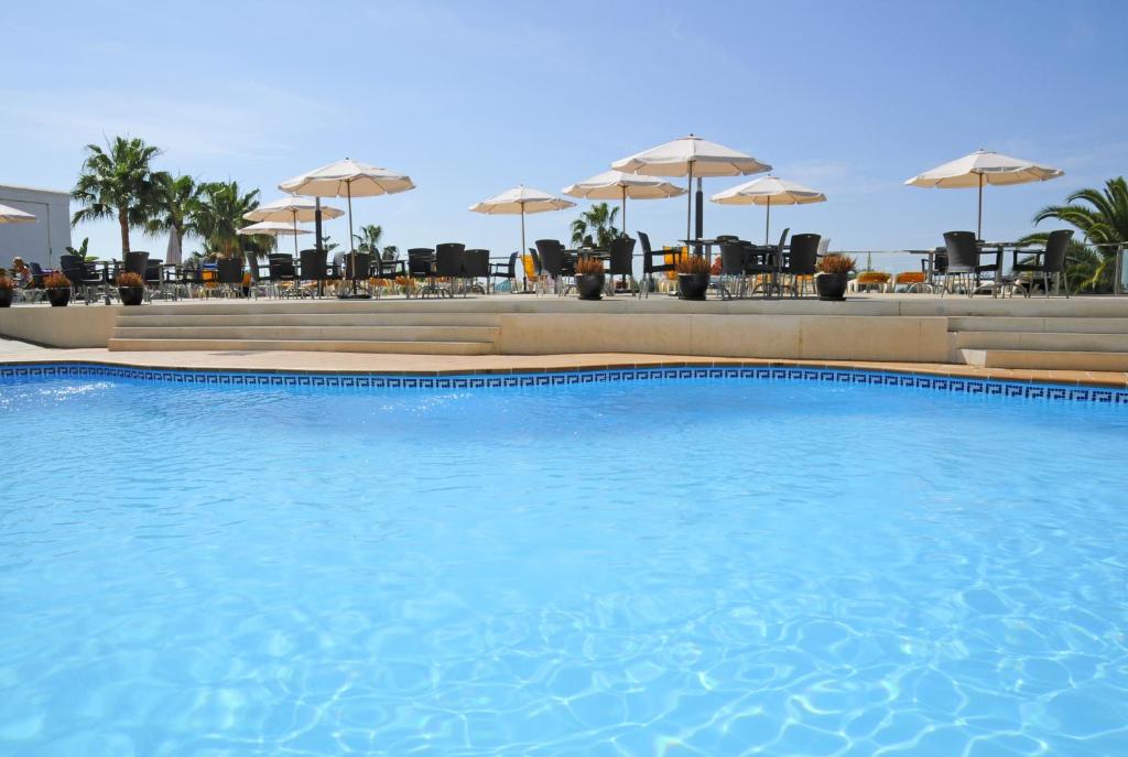 a pool with a blue umbrella on top of it at Hotel Nerja Club Spa by Dorobe in Nerja