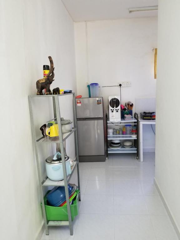 パンタイチェナンにあるImpiana homestay langkawiのキッチン(棚、冷蔵庫付)