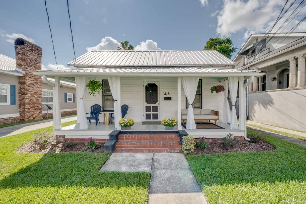 Casa blanca con porche y césped en Updated Early 1900s 2BR Cottage Walking Distance to Downtown with Onsite Parking, en St. Augustine