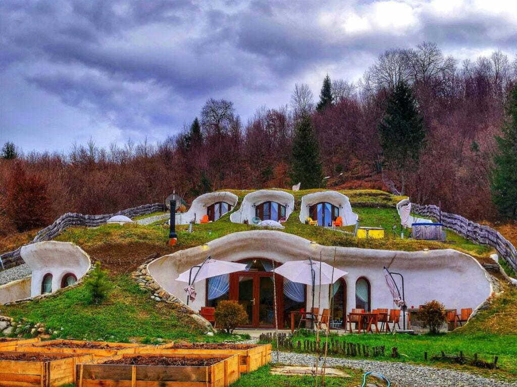 una casa en la cima de una colina cubierta de hierba en Pensiunea Dealul Verde en Porumbacu de Sus