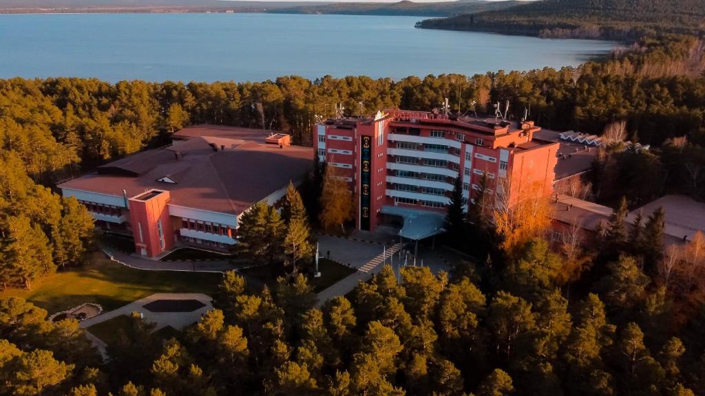 une vue aérienne sur un bâtiment avec des arbres et de l'eau dans l'établissement Лечебно-оздоровительный комплекс Ок-Жетпес, à Borovoe