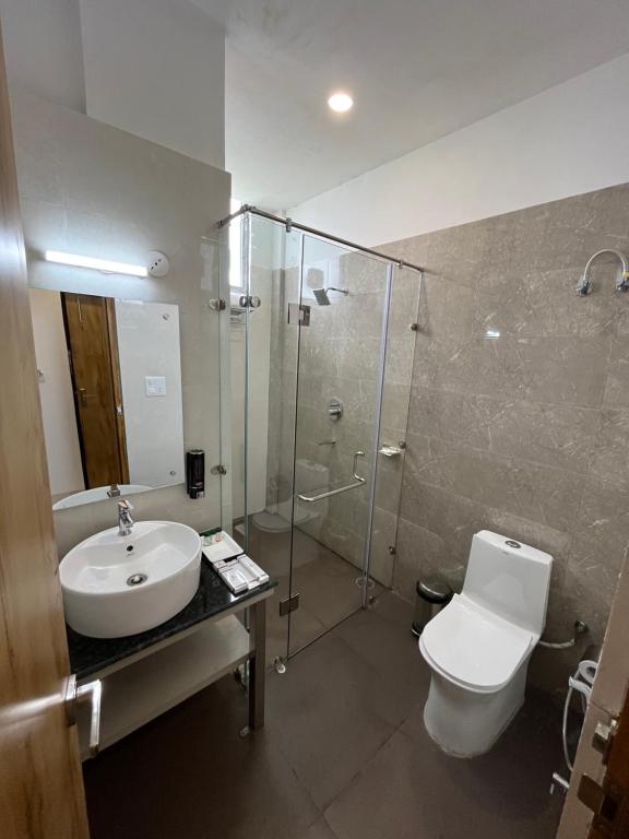 e bagno con lavandino, servizi igienici e doccia. di Click Collection The Abode, Dharamshala a Dharamshala