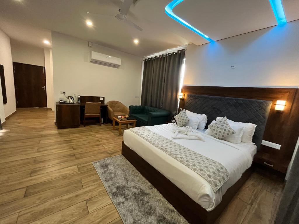 a hotel room with a large bed and a desk at Click Collection The Abode, Dharamshala in Dharamshala