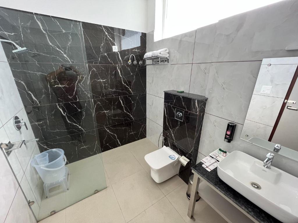 bagno con lavandino, doccia e servizi igienici di Click Collection The Abode, Dharamshala a Dharamshala