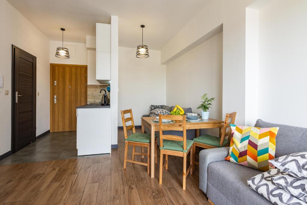 een keuken en een woonkamer met een tafel en een bank bij ENERGYLANDIA Zator Apartament Krzyś in Zator