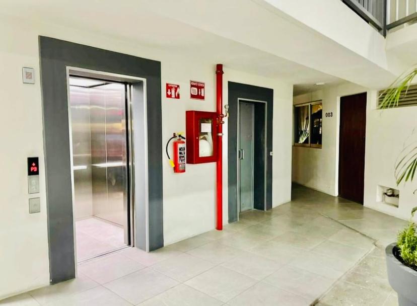 un couloir vide avec une porte dans un bâtiment dans l'établissement Depa M&M, à Guadalajara