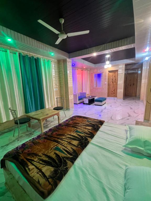ein Schlafzimmer mit einem großen Bett und einem Tisch in der Unterkunft Majestic Mountain Bhaiji Guest House in Kasol