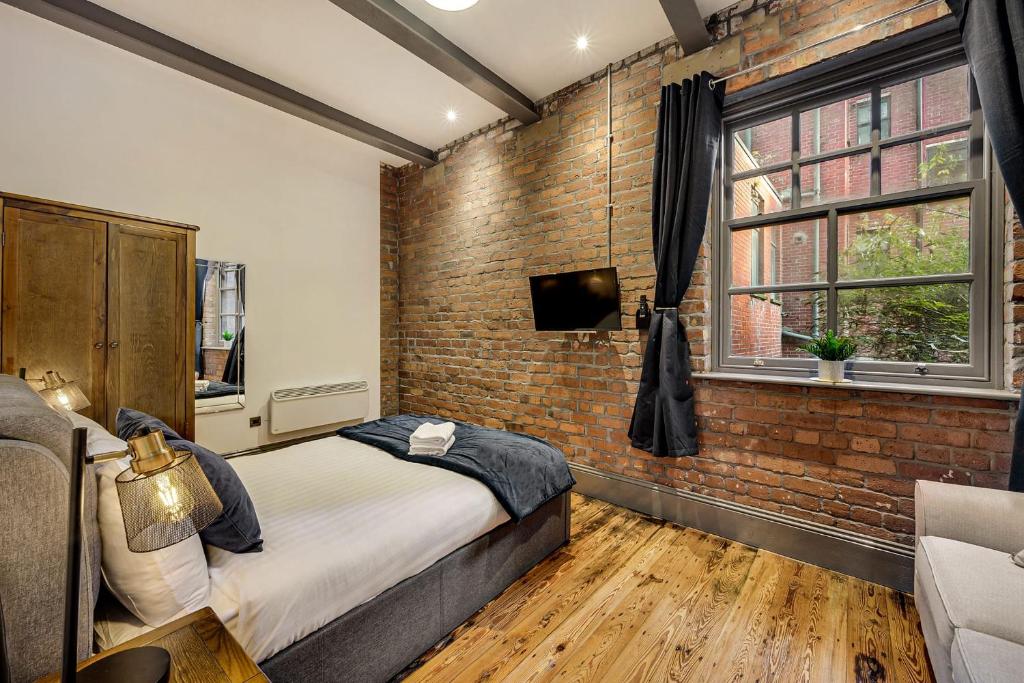 a bedroom with a brick wall and a bed at Host & Stay - Bands Warehouse II in Liverpool