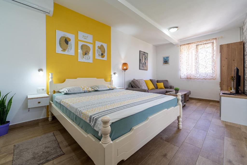 a bedroom with a bed and a yellow wall at Apartments Gruda in Cetinje