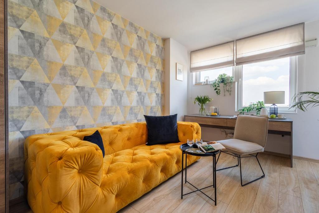 salon z żółtą kanapą i stołem w obiekcie Starter 24 Wrocław we Wrocławiu
