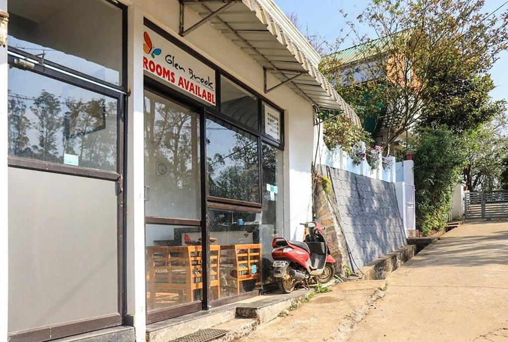 een scooter geparkeerd voor een winkelraam bij Glen Brook Home Stay in Munnar