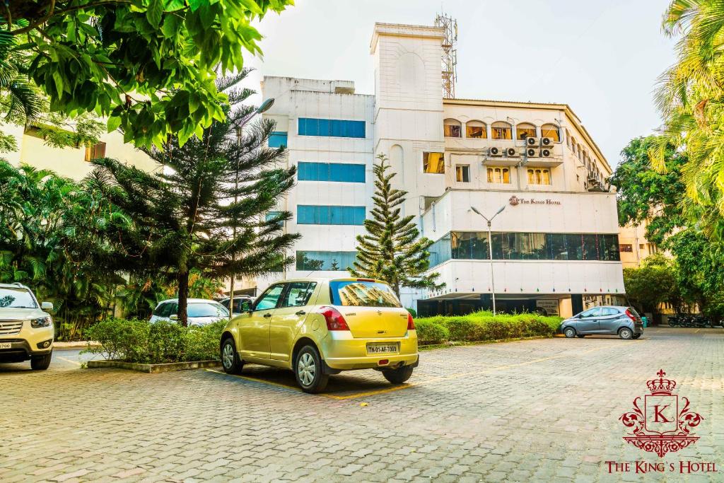 een gele auto geparkeerd voor een gebouw bij Kings Hotel Egmore in Chennai