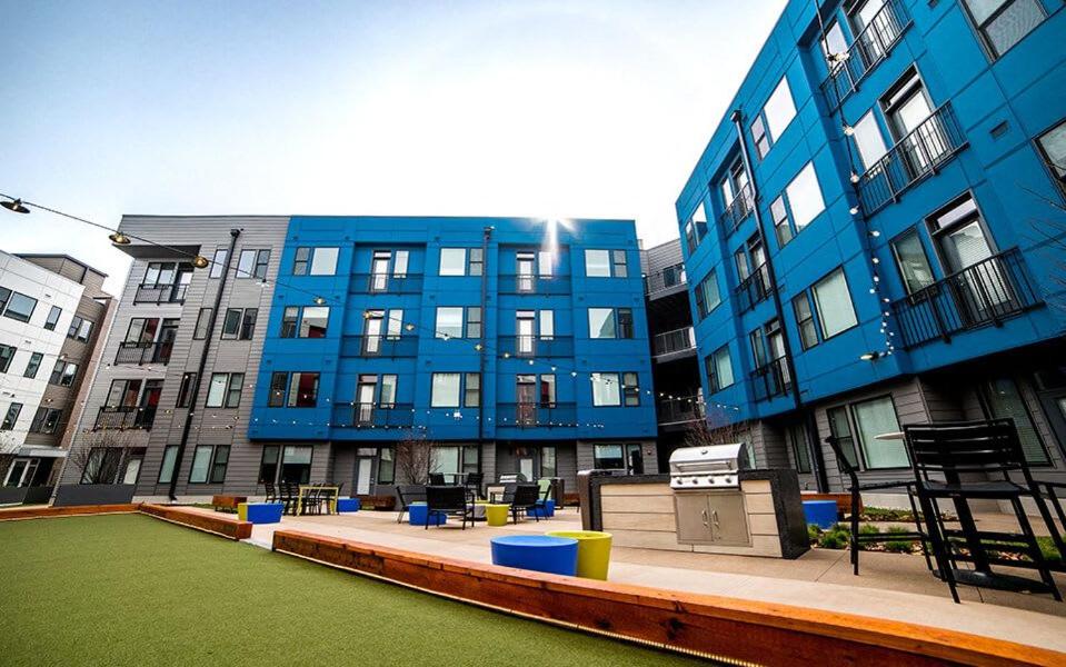 un gran edificio azul con un parque infantil delante de él en Vibrant 2BR Corner Suite and Free Parking at CityWay, en Indianápolis