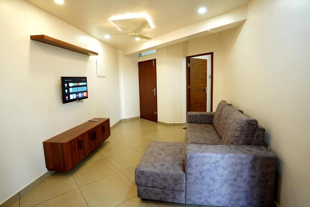 a living room with a couch and a tv at Kadampanattu's Homestay in Ernakulam