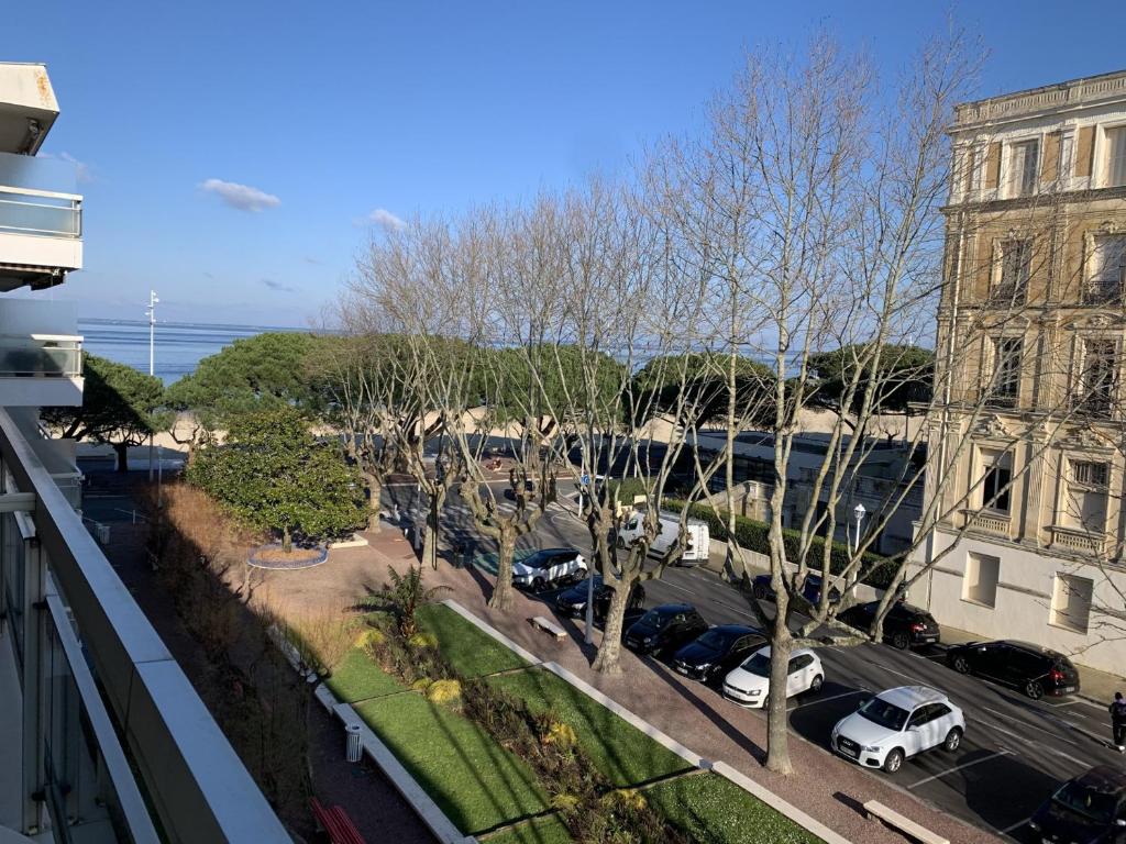 une vue d'un parking avec des voitures garées et un bâtiment dans l'établissement Bel appartement T2 avec parking et Wi-Fi à Arcachon - FR-1-374-170, à Arcachon