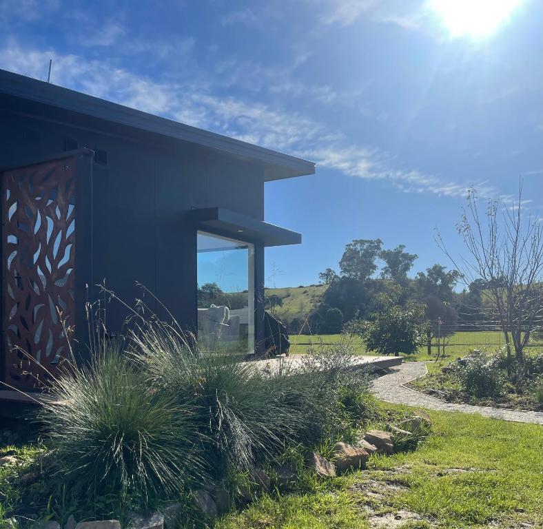 a black building with a door and some grass at Shibui Lilydale Luxury Romance in Lilydale