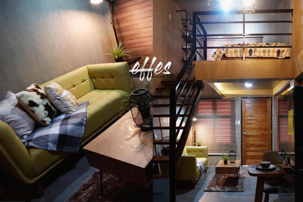 a living room with a green couch and a spiral staircase at 1 bedroom Apartment (Industrial Loft) in Angeles