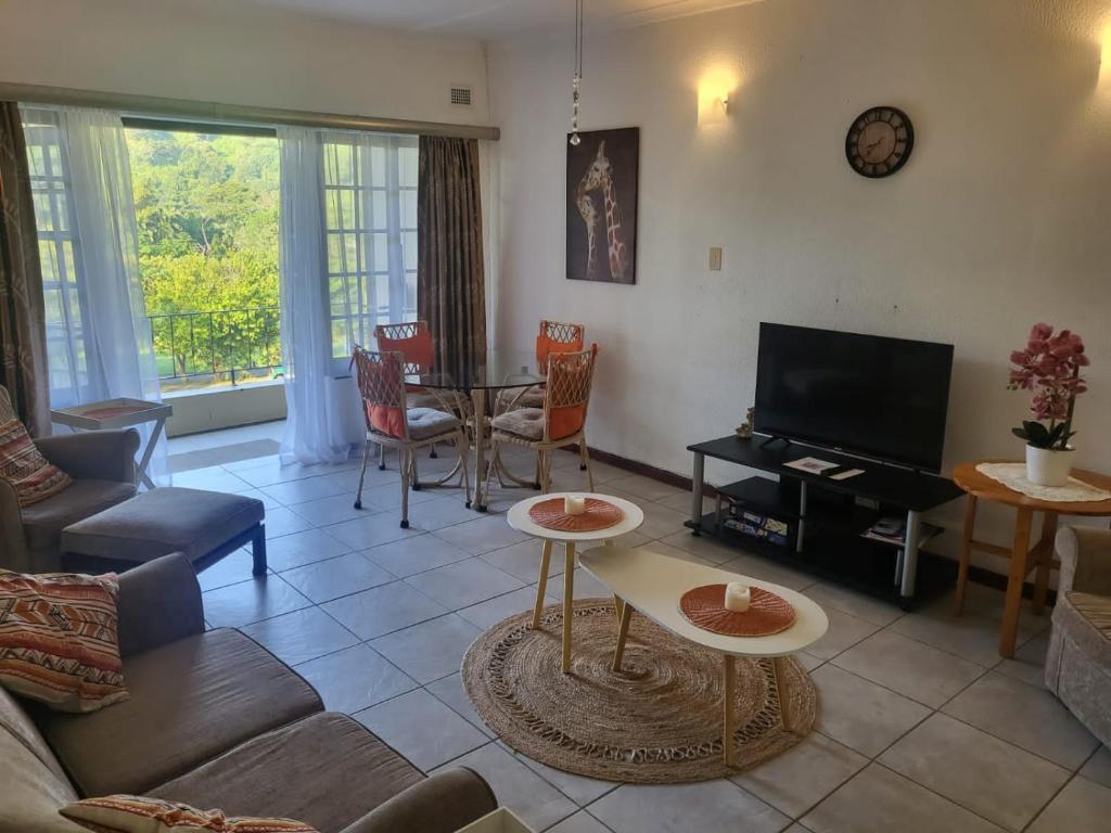 a living room with a couch and a tv at Eden Wilds 38 in Port Edward