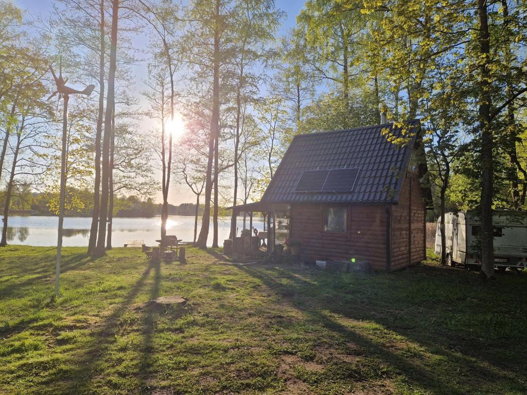 una cabaña en el bosque con el sol brillando entre los árboles en Mini saunahouse, 