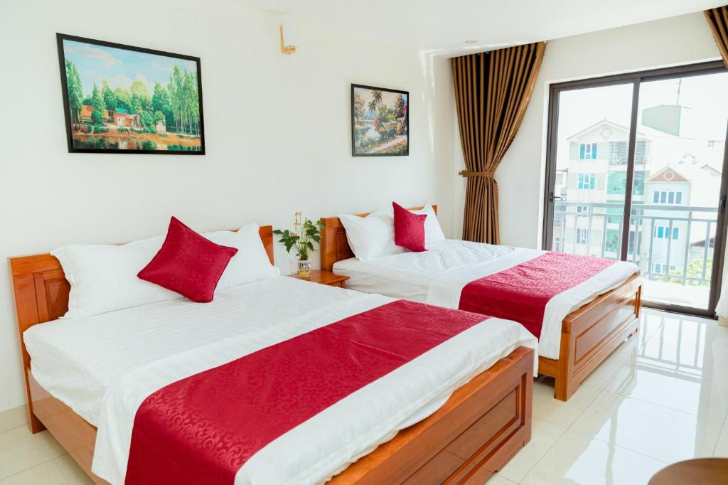 2 Betten in einem Zimmer mit Fenster in der Unterkunft Vĩnh Sơn Nội Bài in Hanoi