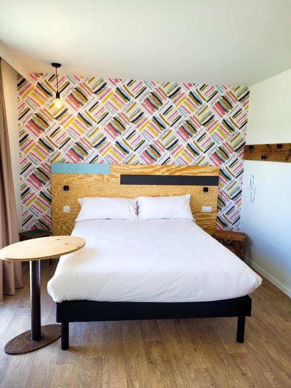 une chambre avec un lit et une table dans l'établissement greet hotel Castets Coeur des Landes, à Castets
