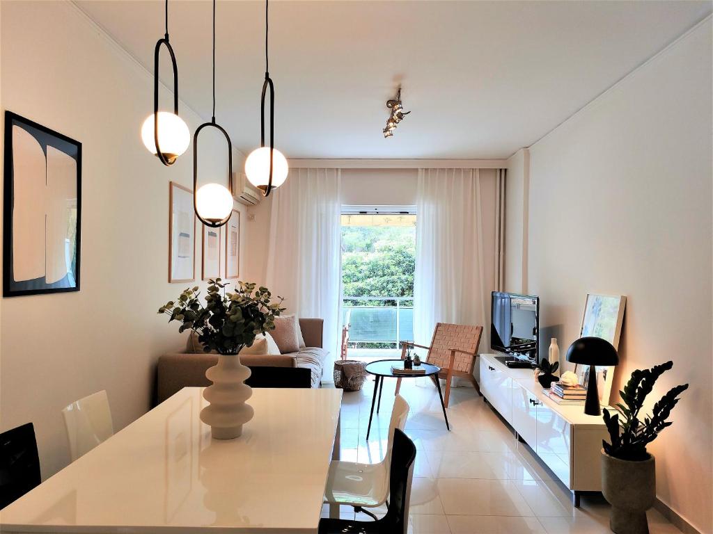 a living room with a table and a couch at Vouliagmeni Iasonos Residence Central Stylish Flat in Athens