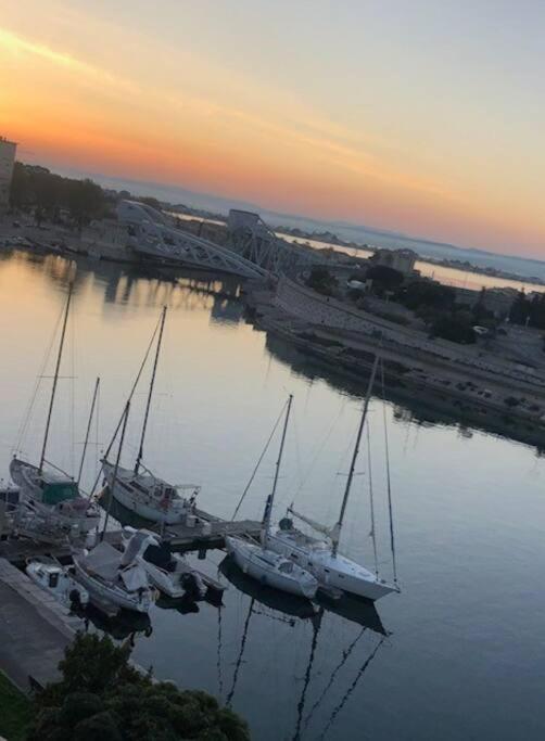 un groupe de bateaux amarrés dans un port au coucher du soleil dans l'établissement Séte 6eme vue sur le canal et l'étang, à Sète