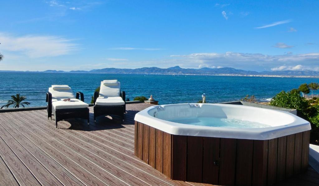 una bañera de hidromasaje en una terraza junto al océano en Casa Pura - Luxuriöses Ferienhaus mit Meerblick, en Llucmajor