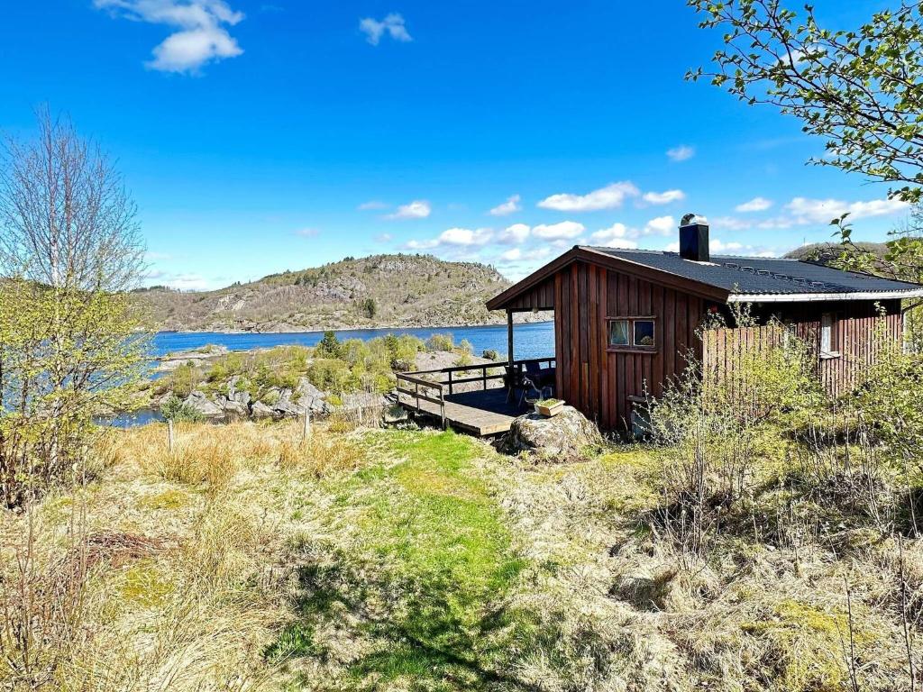 una cabina in legno sul lato di un lago di 5 person holiday home in FARSUND a Helle