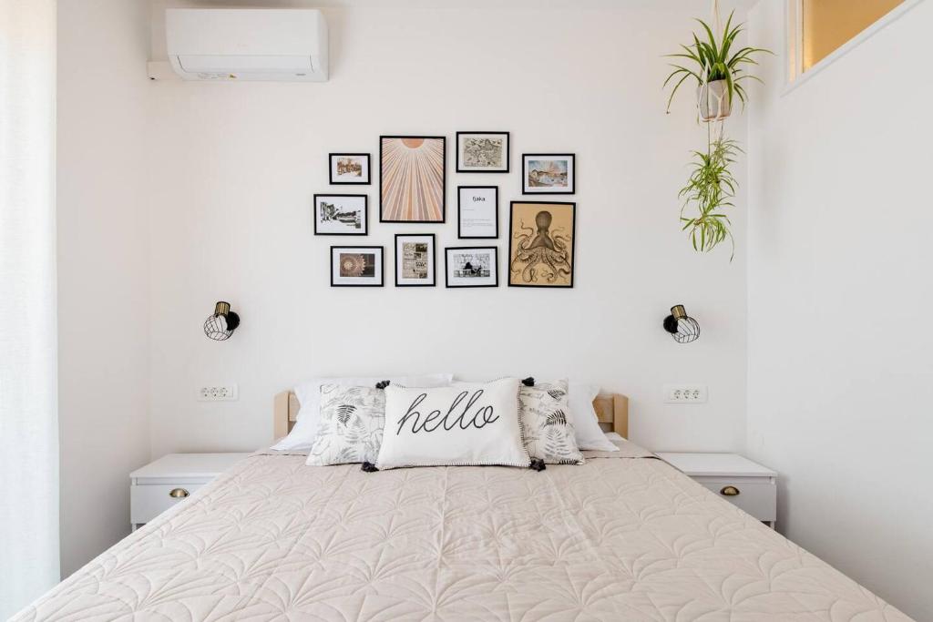 a white bedroom with a large bed with pillows at Guest House Vuljan in Hvar