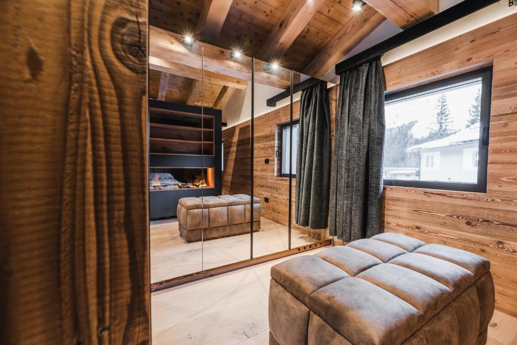 un soggiorno con pannelli in legno e una grande finestra di Chalet Queen a Canazei