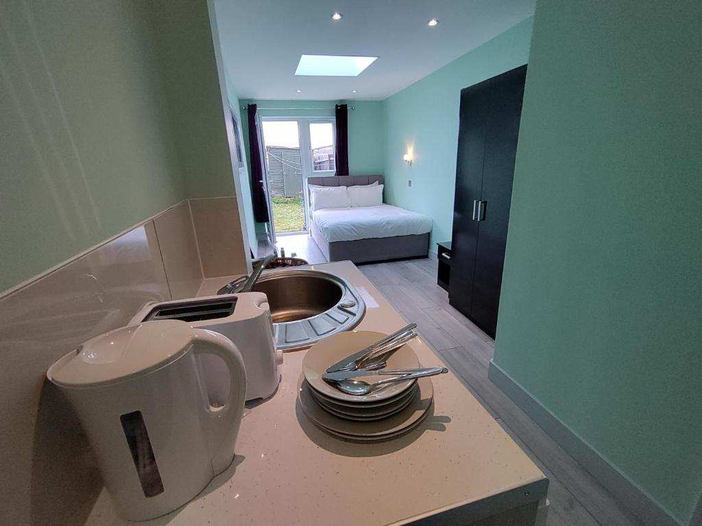 a kitchen with a counter with a sink and a stove at Letzi Private En-Suite, Near Heathrow Airport T3 in Hayes