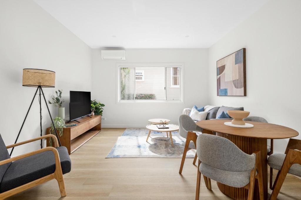 una sala de estar con una mesa y un sofá en Urban Rest Neutral Bay Apartments, en Sídney