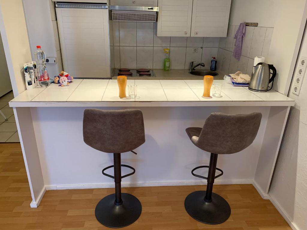 a kitchen with two bar stools and a counter at Ferienappartment Möhnesee in Möhnesee