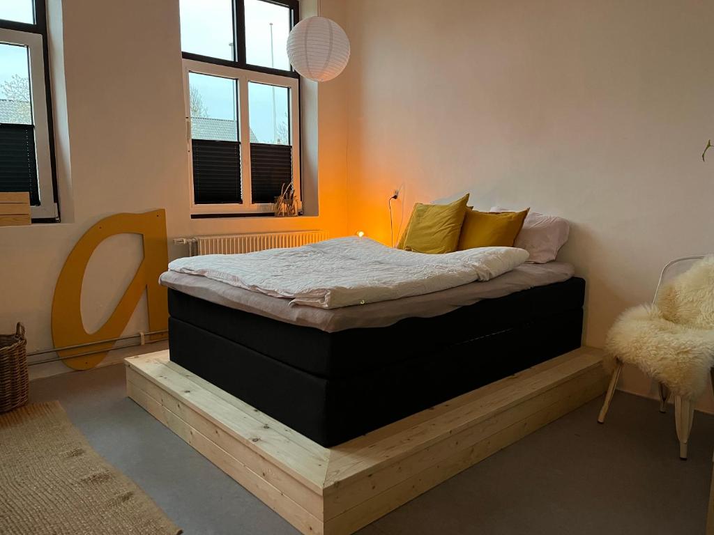 uma cama numa plataforma de madeira num quarto em Room 9 -Hawkraft kulturhotel em Vestervig