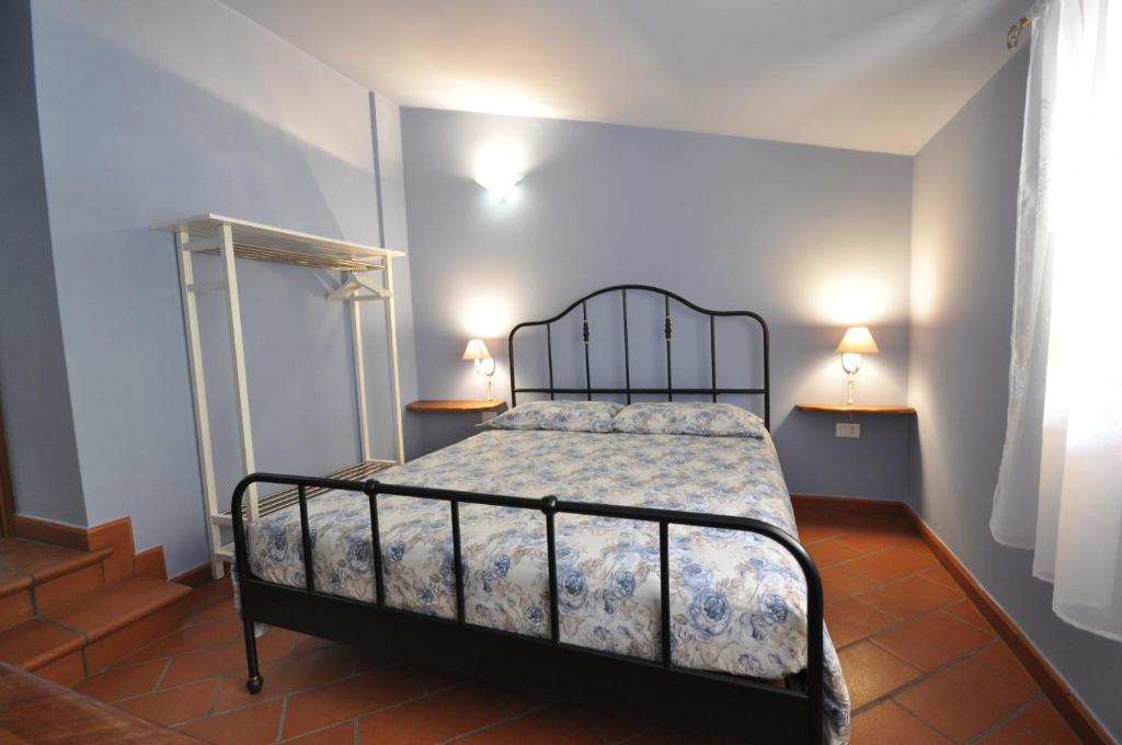 a bedroom with a bed with two lamps on the wall at La Corte del Monte 
