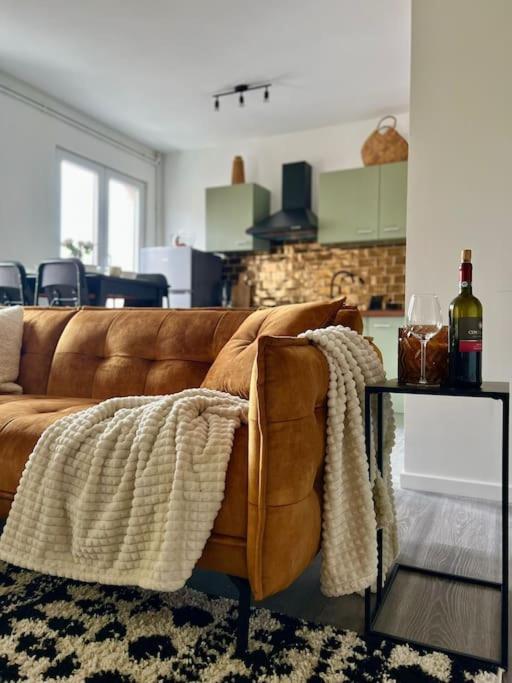 un soggiorno con divano marrone e tavolo di Lovely 2-bedroom Duplex w/ balcony in Brussels a Bruxelles