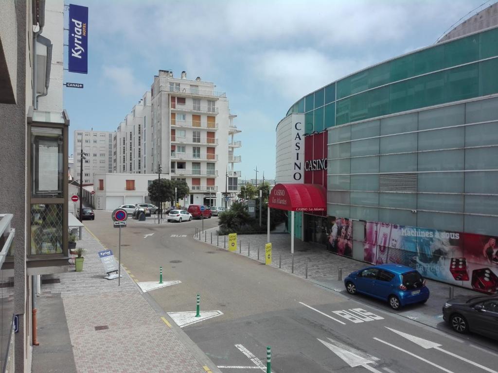 une vue d'une rue avec un bâtiment et une voiture bleue dans l'établissement Studio rénové avec balcon à 100m de la plage et piscine - 4 personnes - Les Sables-d'Olonne - FR-1-331-204, à Les Sables-dʼOlonne