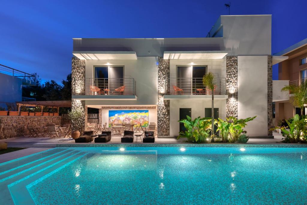 a villa with a swimming pool at night at Saronis Suites in Saronida