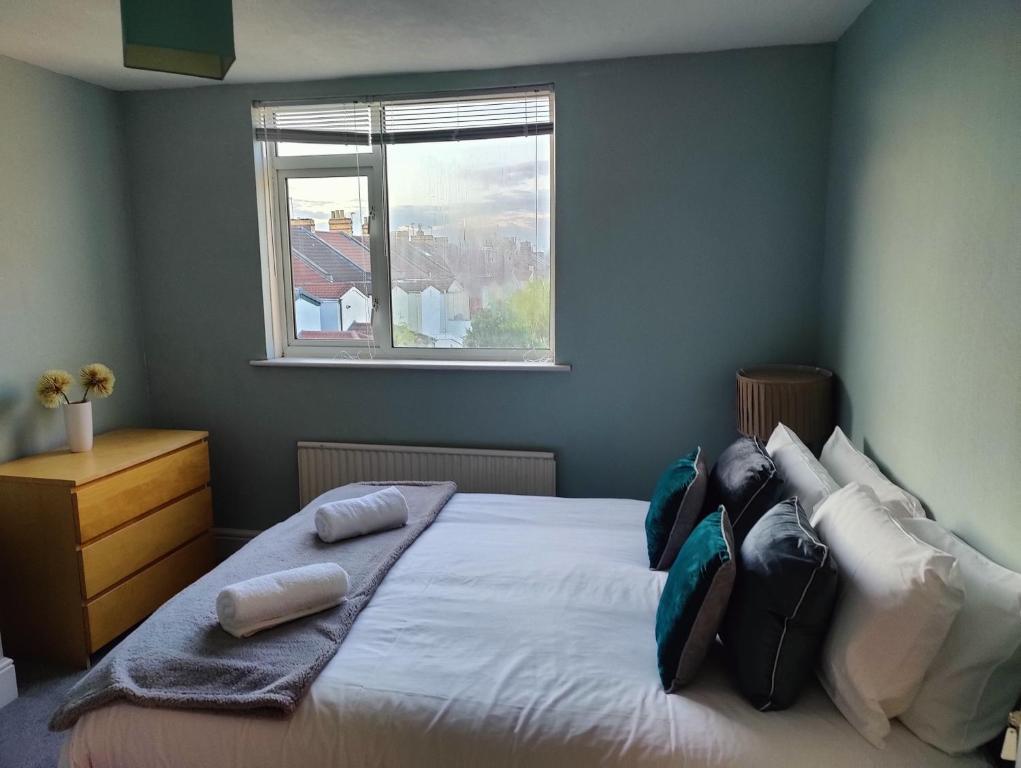 1 dormitorio con cama con almohadas y ventana en Beachgrove House en Bristol