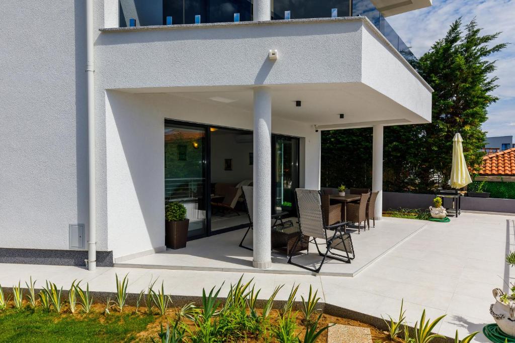 een patio met eethoek in een huis bij Apartment "Villa M" in Kostrena