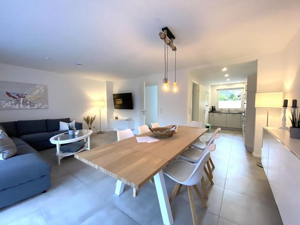 ein Wohnzimmer mit einem Tisch und einem blauen Sofa in der Unterkunft Moderne, hochwertig ausgestattete Hausscheibe in Sackgassenlage! in Westerholz