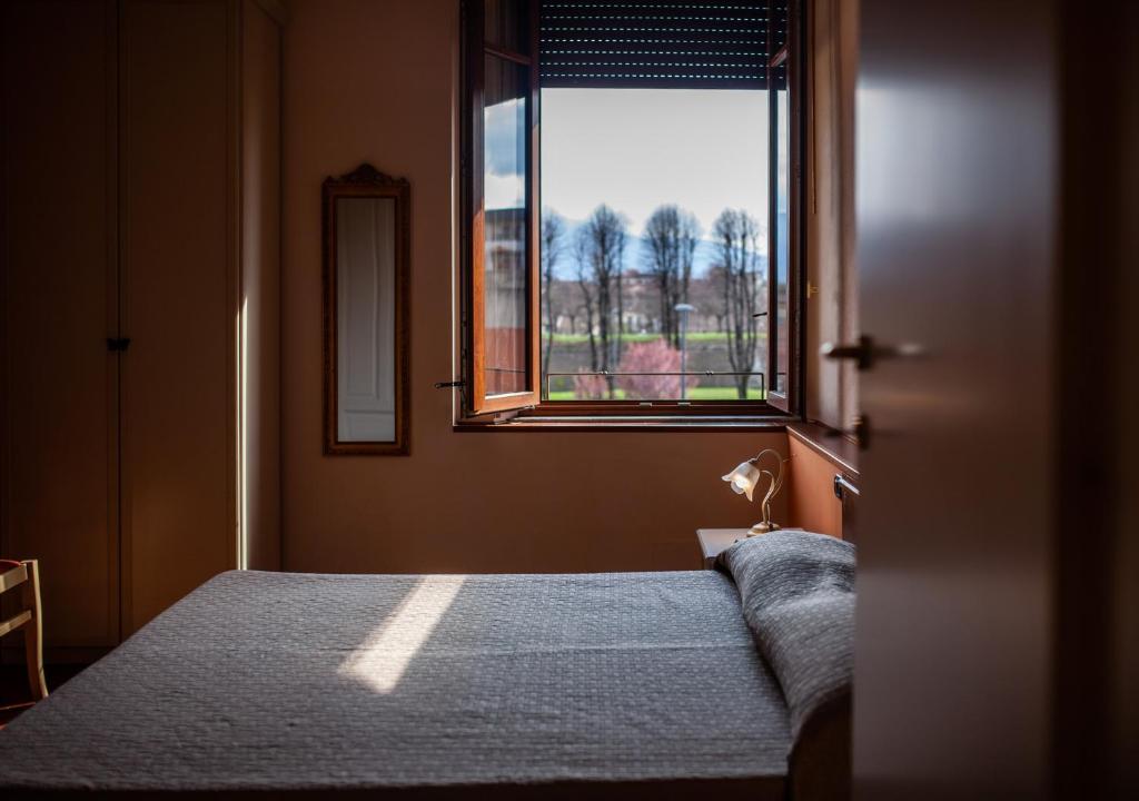 a bedroom with a bed and a window at Liberty Guest House in Lucca