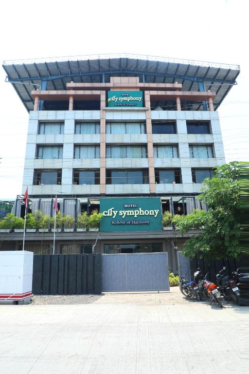 a large office building with motorcycles parked in front of it at Hotel City Symphony in Nānded