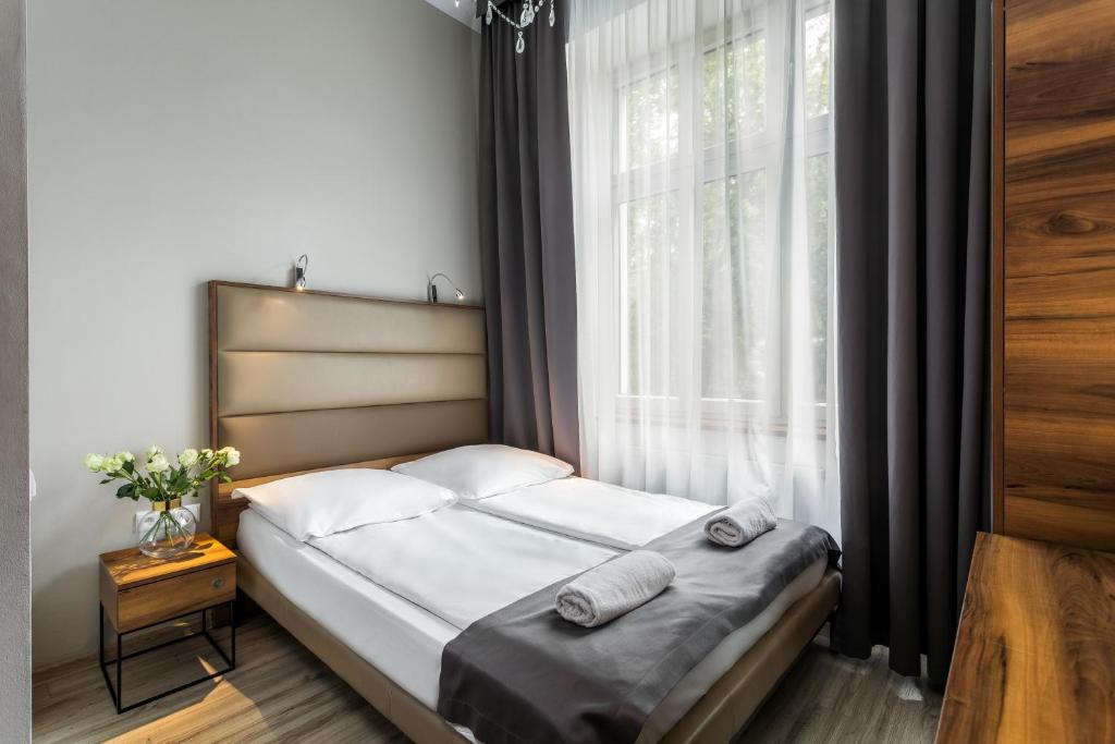 a bed in a room with a large window at Grodzka Royal Apartments in Krakow