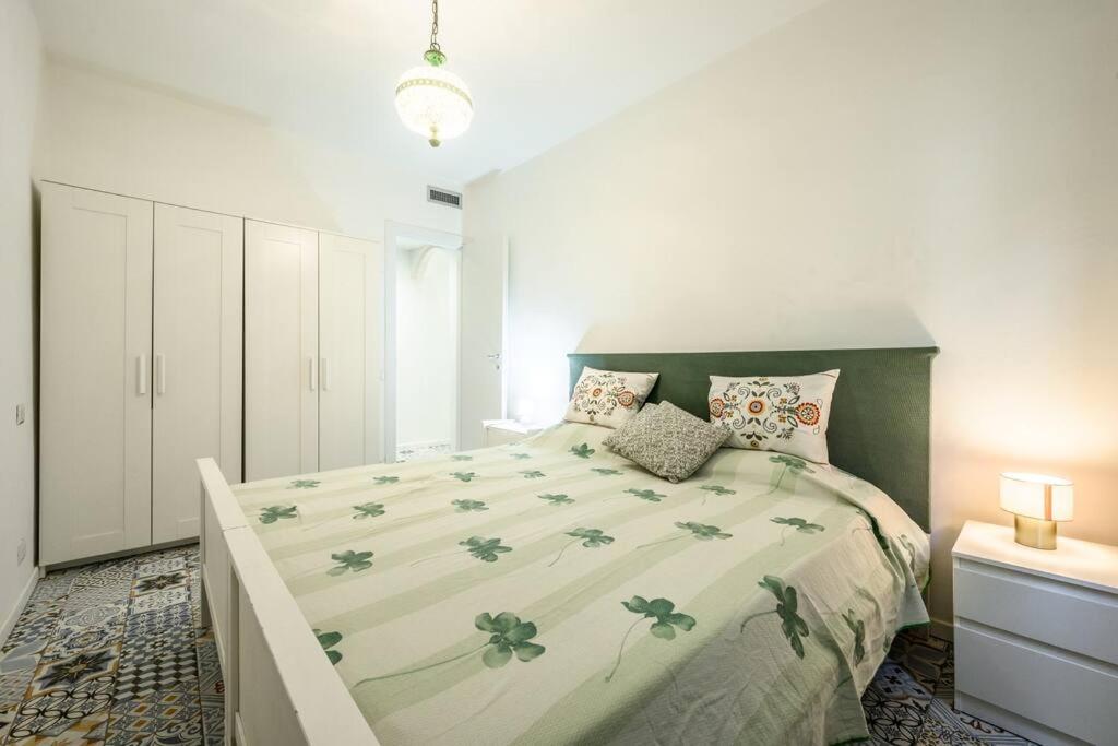een slaapkamer met een groot bed met een groene sprei bij Le Finestre sul Borgo 2 in Parma
