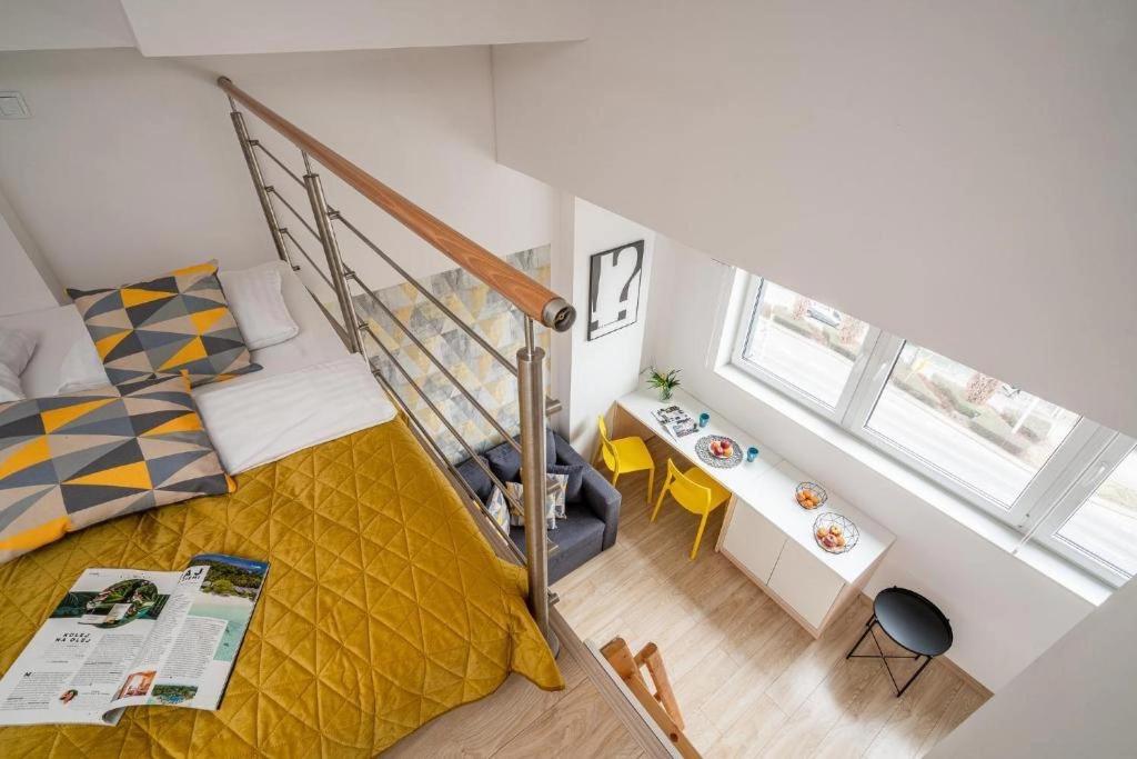 a small bedroom with a bed and a staircase at StarterApart Wrocław in Wrocław