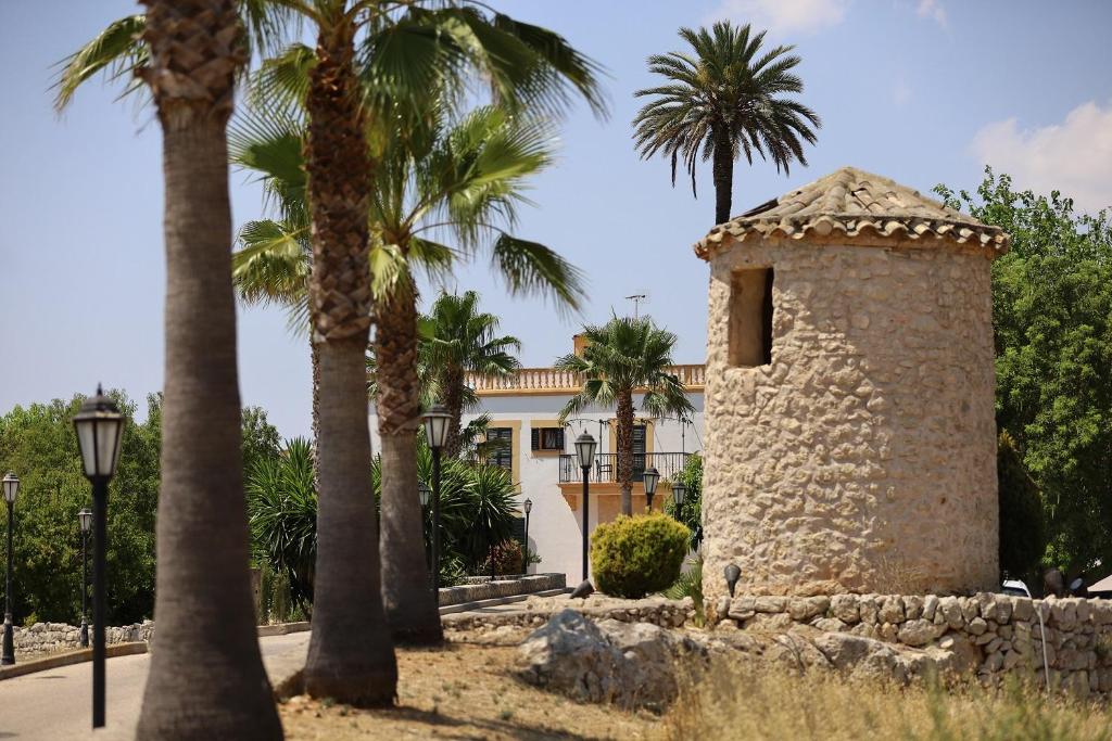 un bâtiment avec des palmiers en face d'une rue dans l'établissement Finca Son Manera, à Montuiri